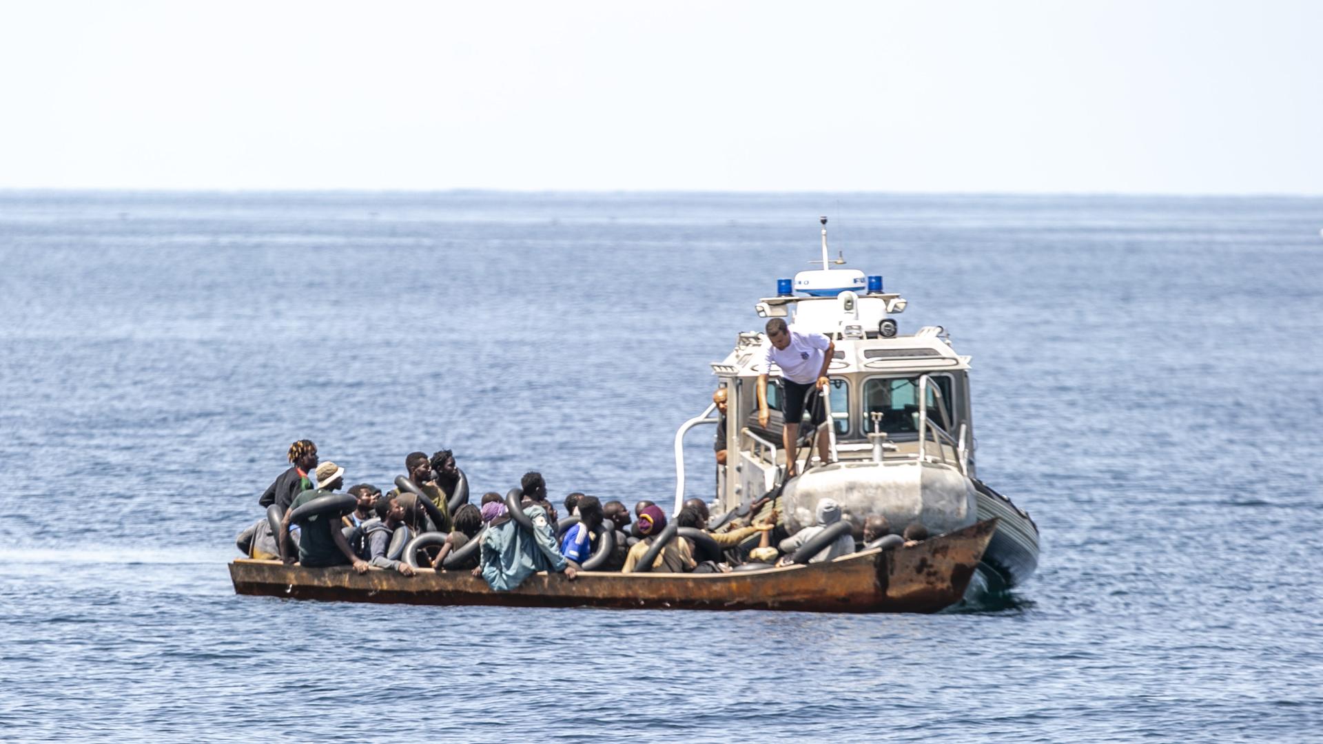 Ein Boot der tunesischen Küstenwache hat an einem mit Menschen überfüllten Kahn festgemacht.