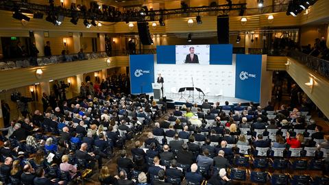 Blick von oben in den vollbesetzten Saal mit Bühne. 