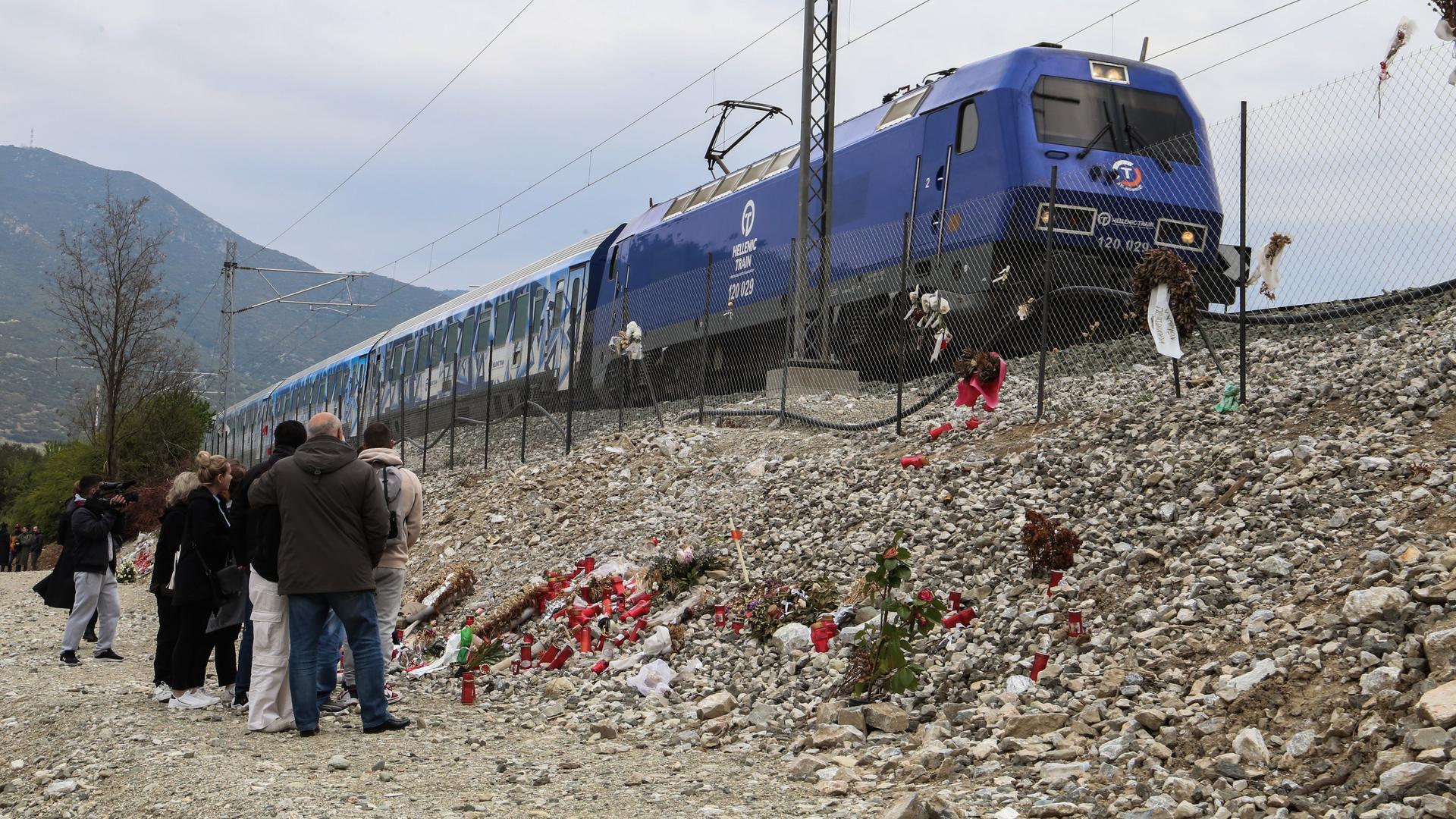 Kerzen, Blumen und Fotos als Zeichen der Trauer am Bahndamm bei Tempi, Griechenland, wo das Zugunglück 2023 stattfand.