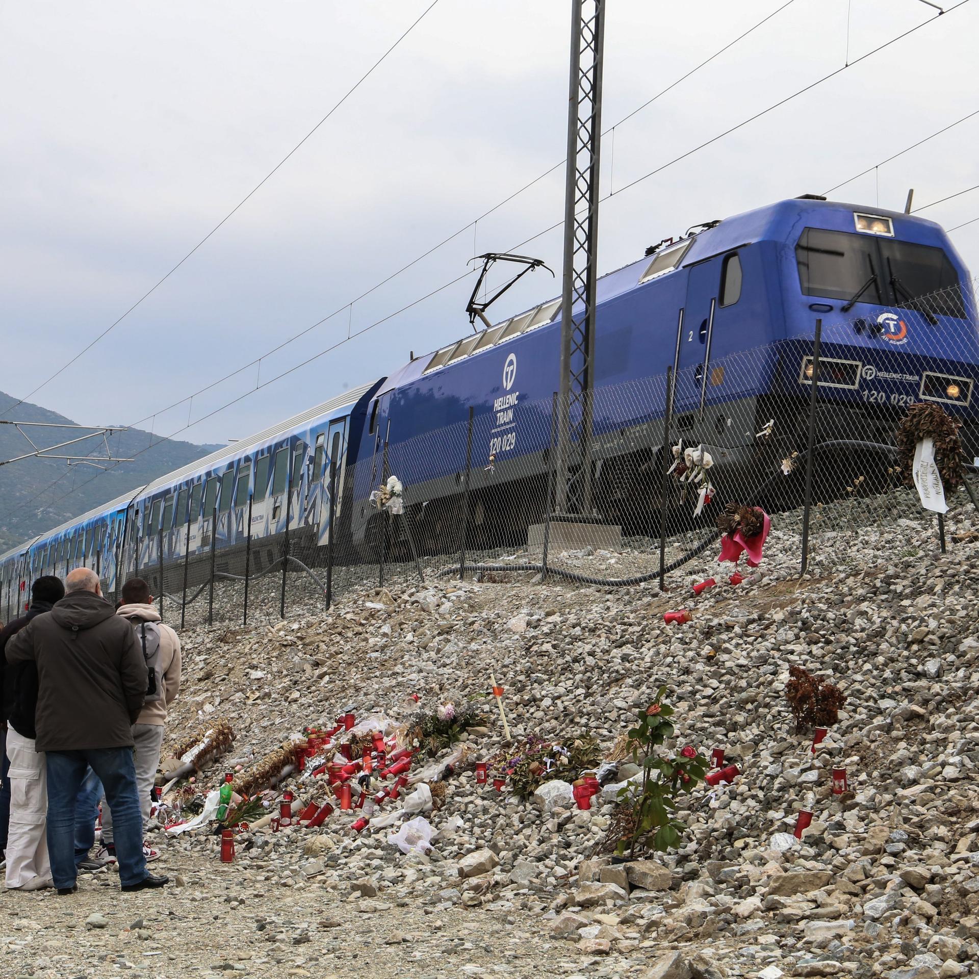 Kerzen, Blumen und Fotos als Zeichen der Trauer am Bahndamm bei Tempi, Griechenland, wo das Zugunglück 2023 stattfand.