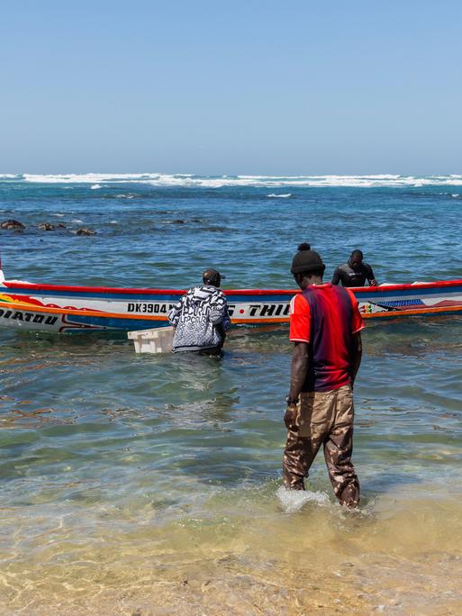 Fischer mit ihrem Boot in Dakar, Senegal.