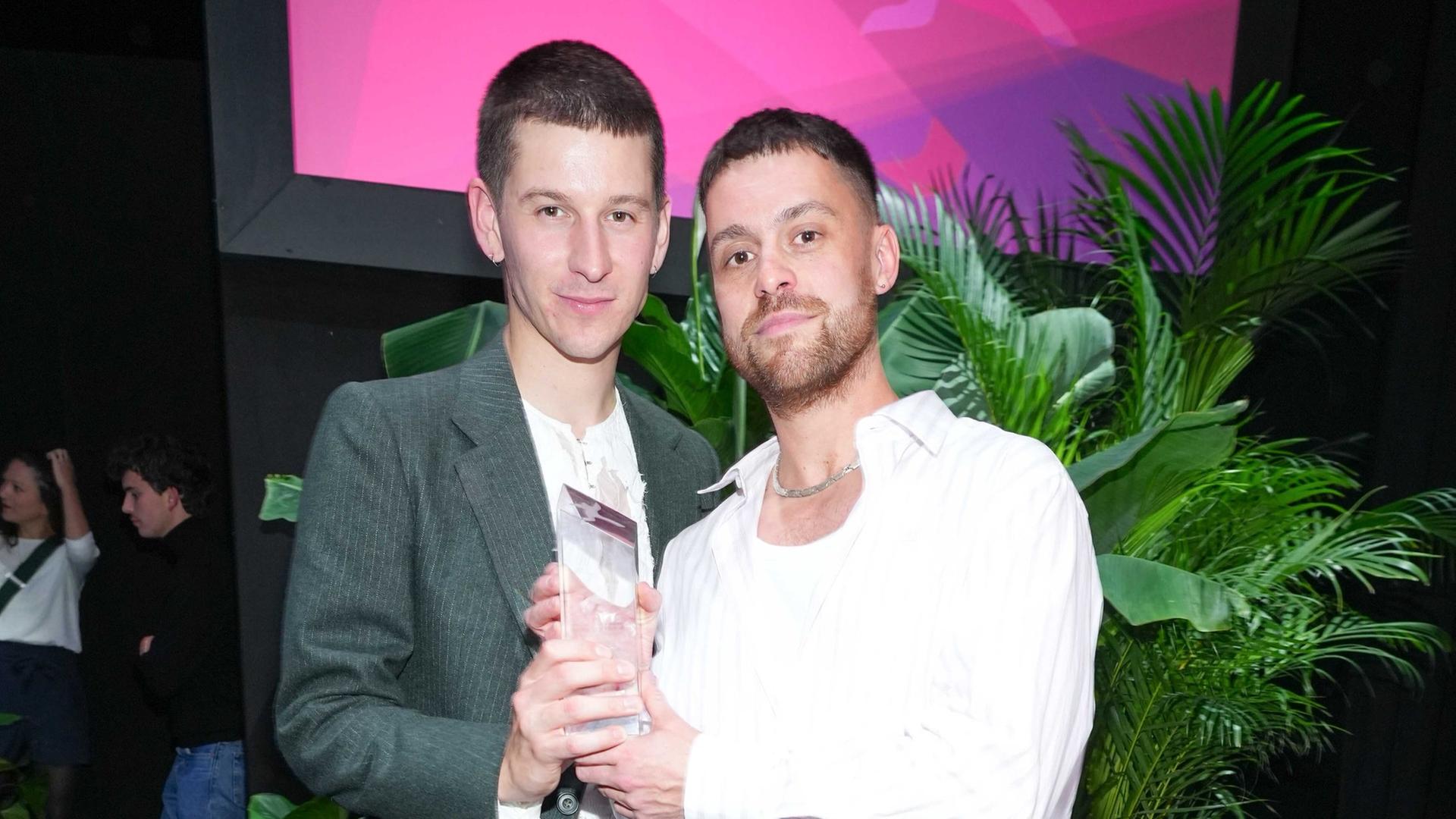 Lorenz Hochhuth und Hannes Hirsch bei der Verleihung der First Steps Awards im Stage Theater des Westens in Berlin. Die beiden stehen nebeneinander, beide halten die Trophäe fest. Lorenz Hochhuth und Hannes Hirsch bei der Verleihung der First Steps Awards im Stage Theater des Westens in Berlin. Die beiden stehen nebeneinander, beide halten die Trophäe fest.