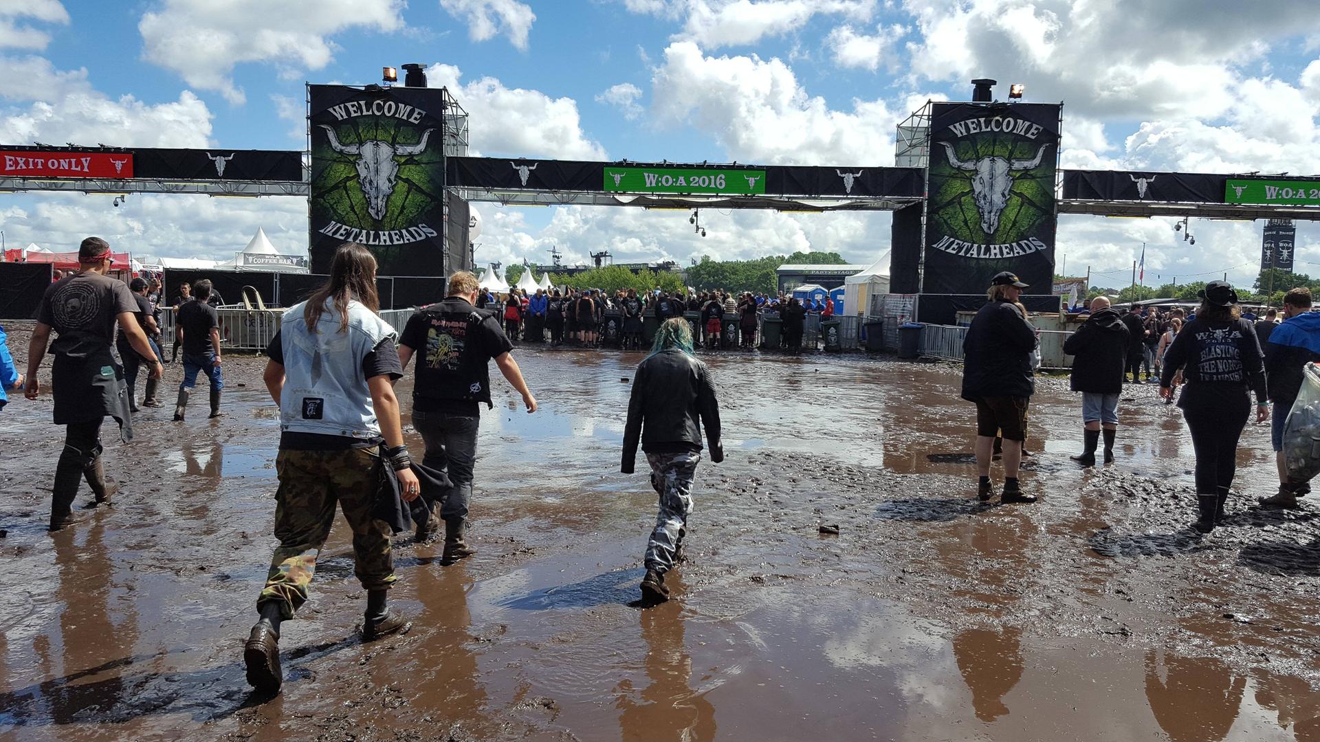 Der Eingang des Wacken-Open-Air. Die Fans laufen durch den Schlamm. Der Eingang des Wacken-Open-Air. Die Fans laufen durch den Schlamm.