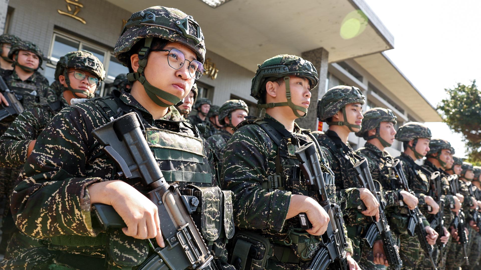 Taiwanesische Soldaten stehen in mehreren Reihen. Sie tragen Uniform, Helme und Gewehre. Taiwanesische Soldaten stehen in mehreren Reihen. Sie tragen Uniform, Helme und Gewehre.