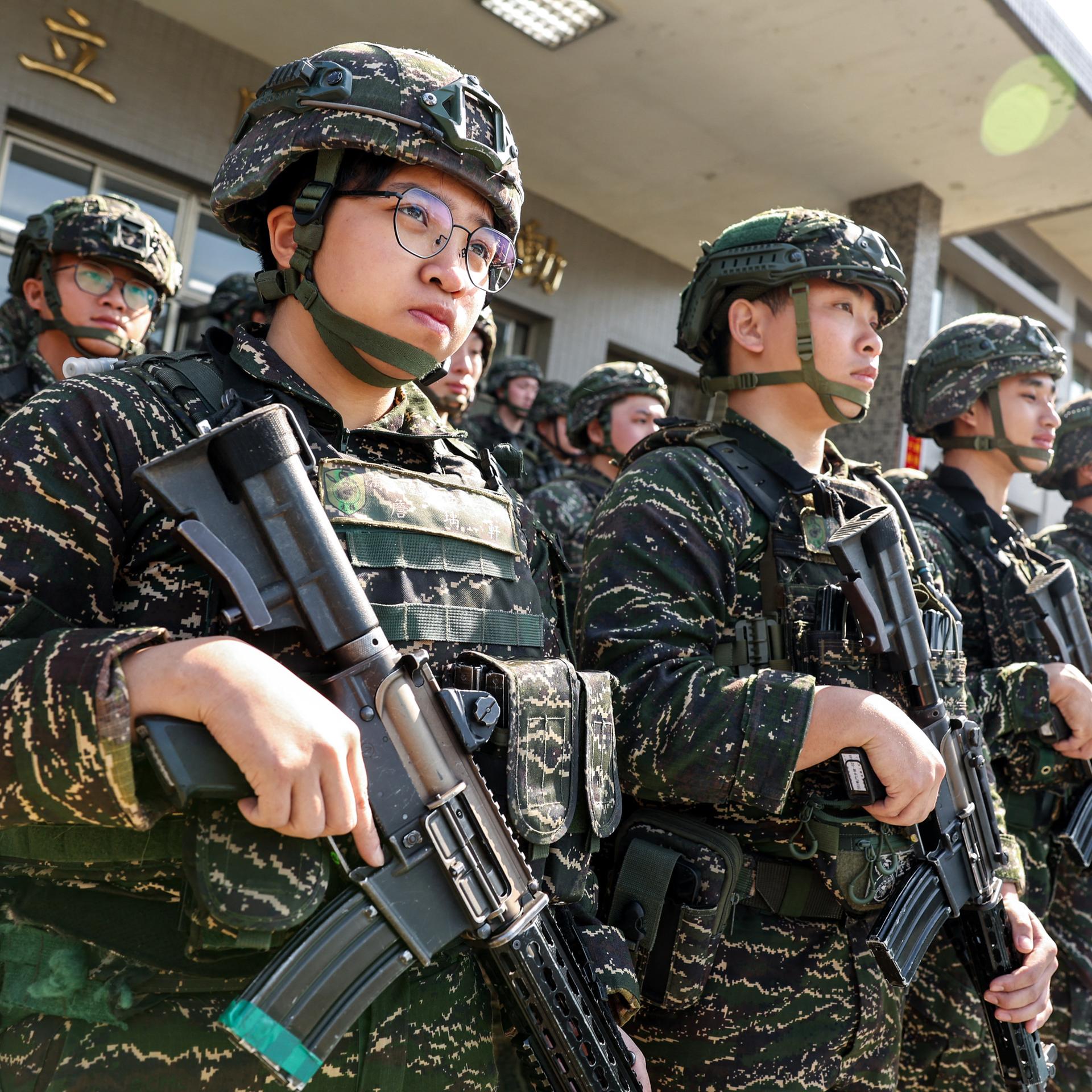 Taiwanesische Soldaten stehen in mehreren Reihen. Sie tragen Uniform, Helme und Gewehre.