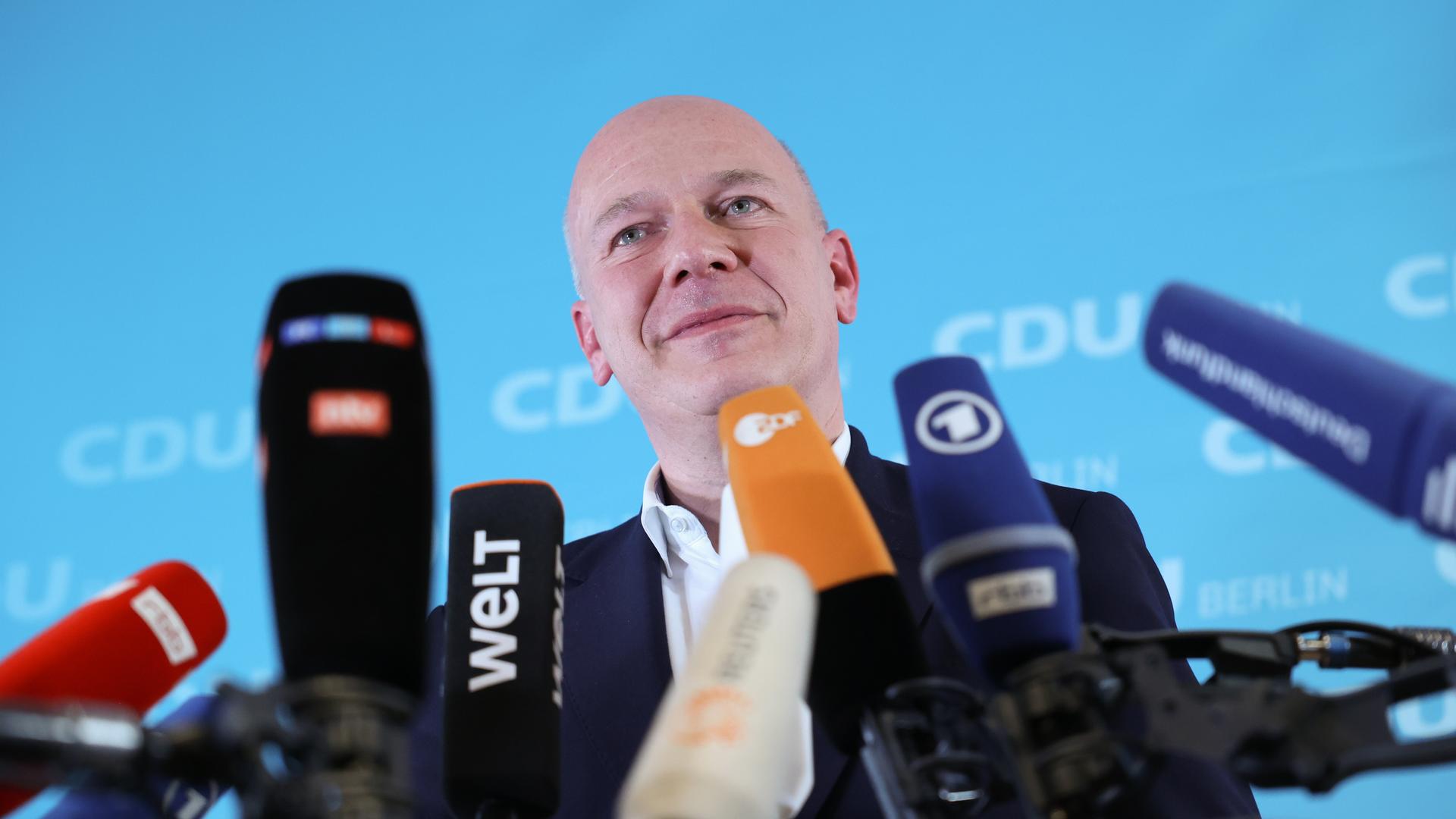 Kai Wegner spricht in zahlreiche Mikrofone Kai Wegner spricht in zahlreiche Mikrofone