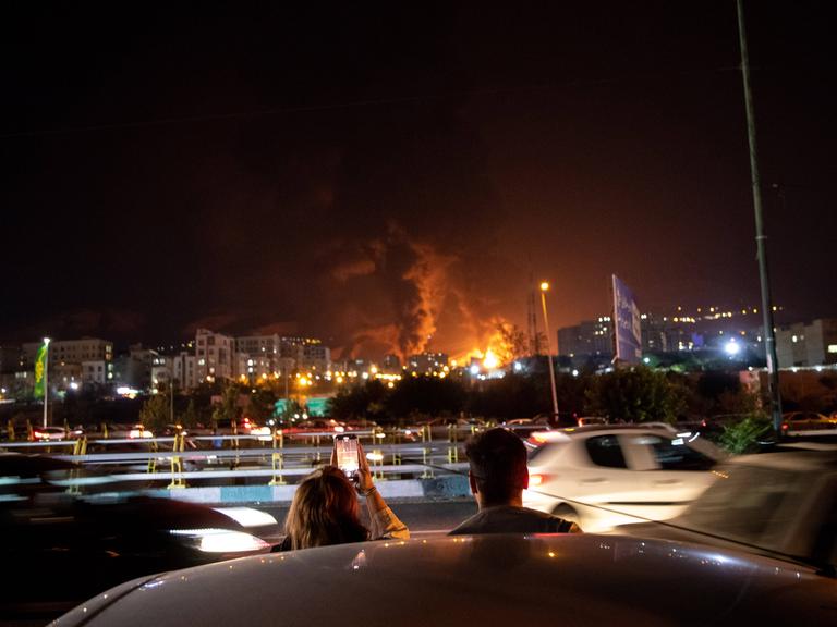 Iraner beobachten am Sonntag, den 15.06.2025, die iranische Hauptstadt Teheran während eines israelischen Luftangriffs