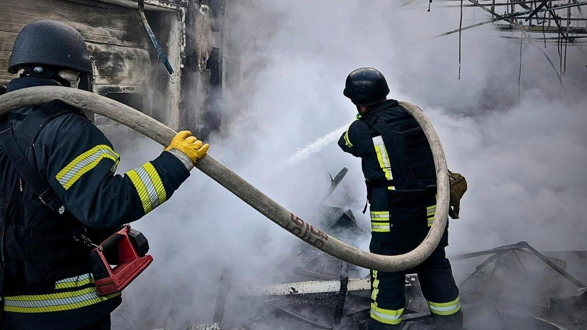 Ukrainische Feuerwehrleute löschen einen Brand in einer Halle. Ukrainische Feuerwehrleute löschen einen Brand in einer Halle.