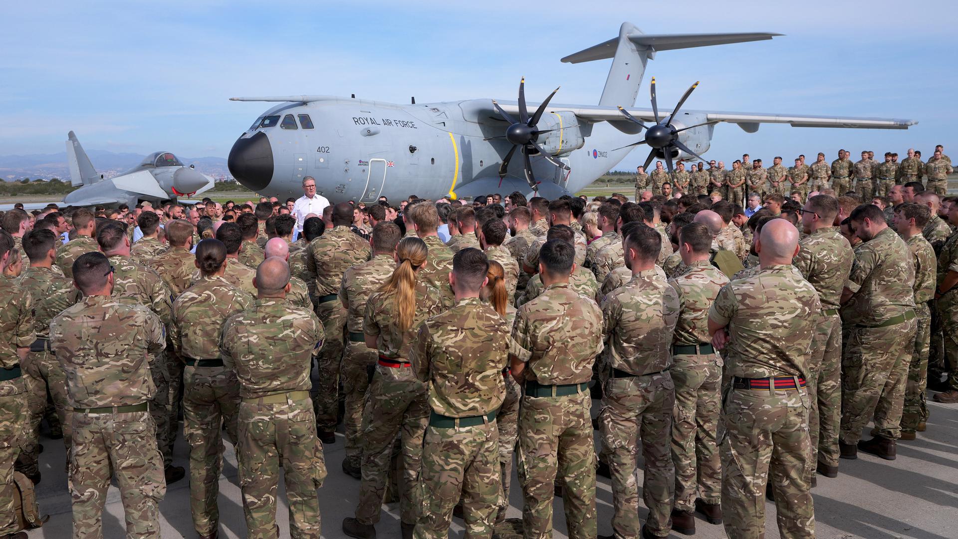 Der britische Premierminister Keir Starmer steht vor einer Maschine der Royal Air Force. Davor haben sich zahlreiche Soldaten versammelt. Der britische Premierminister Keir Starmer steht vor einer Maschine der Royal Air Force. Davor haben sich zahlreiche Soldaten versammelt.