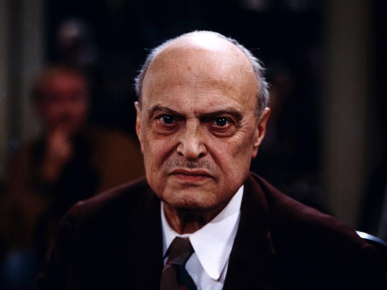 Ein Portrait von 1983 zeigt Sebastian Haffner, den bedeutenden deutsch-britischen Historiker, Publizist, Schriftsteller und Journalist. Er trägt einen Anzug und schaut mit ernster Miene in die Kamera.