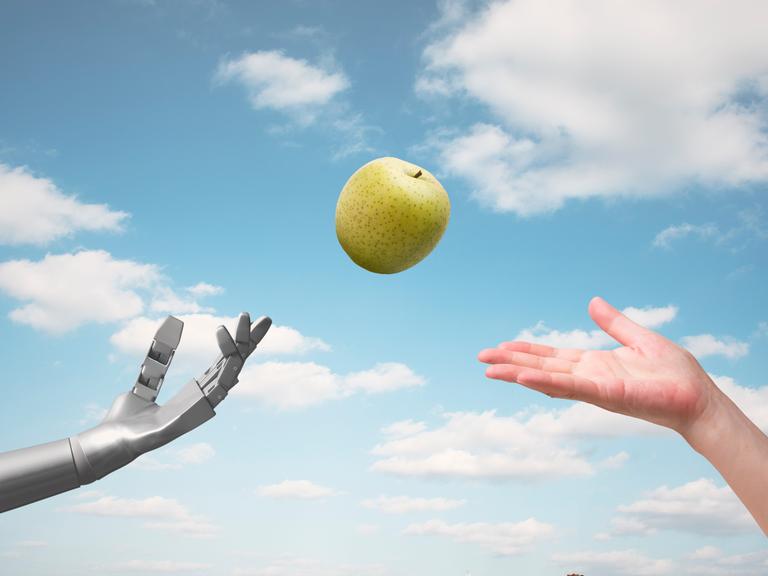 Illustration eines fliegenden Apfels, nach dem sich zugleich eine menschliche und eine Roboterhand recken.