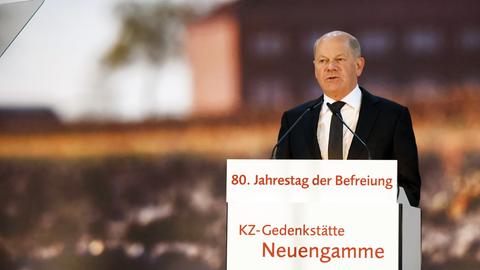 Scholz hinter einem Rednerpult im dunklen Anzug und mit dunkler Krawatte