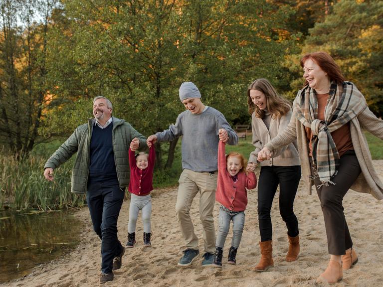 Familie verbringt ihre Freizeit miteinander beim Spazierengehen im Sand Familie verbringt ihre Freizeit miteinander beim Spazierengehen im Sand