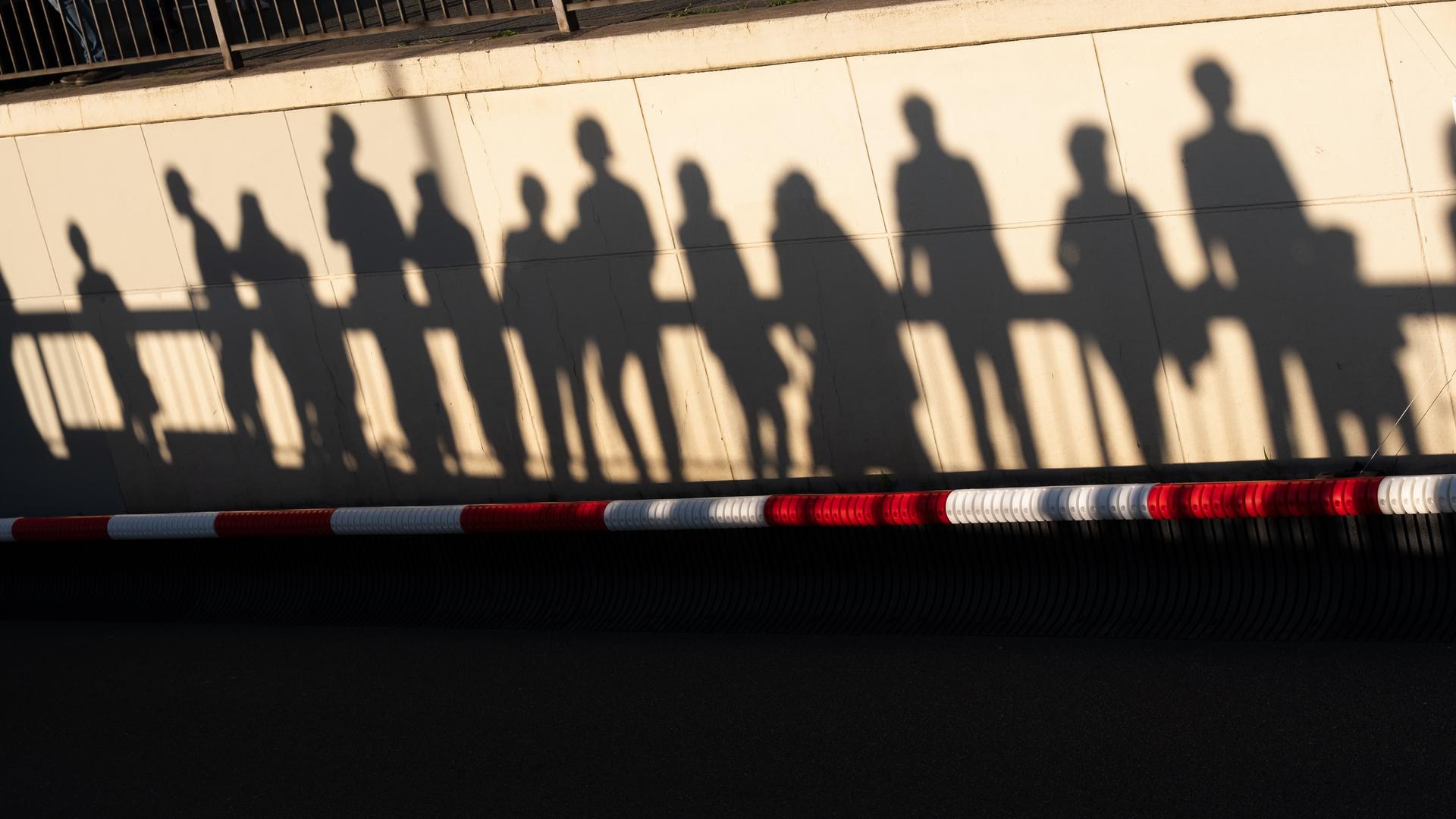 Silhouetten von Zuschauern einer Veranstaltung des Bürgerfestes zum Tag der Deutschen Einheit 2026 in Bremen über einem rot-weißen Absperrband. 