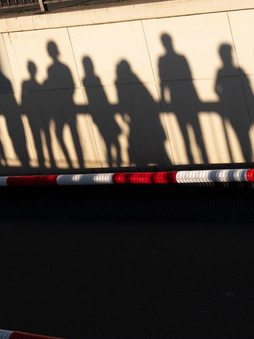 Silhouetten von Zuschauern einer Veranstaltung des Bürgerfestes zum Tag der Deutschen Einheit 2026 in Bremen über einem rot-weißen Absperrband. 