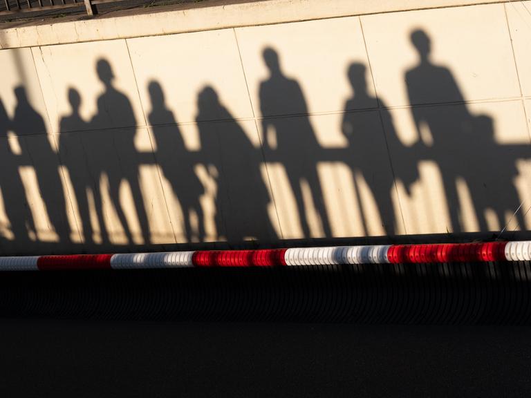 Silhouetten von Zuschauern einer Veranstaltung des Bürgerfestes zum Tag der Deutschen Einheit 2026 in Bremen über einem rot-weißen Absperrband. 