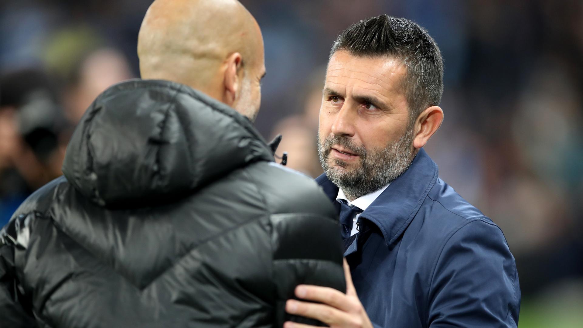 Pep Guardiola (l), Trainer von Manchester City, und Nenad Bjelica, Trainer von Dinamo Zagreb, sprechen miteinander. 