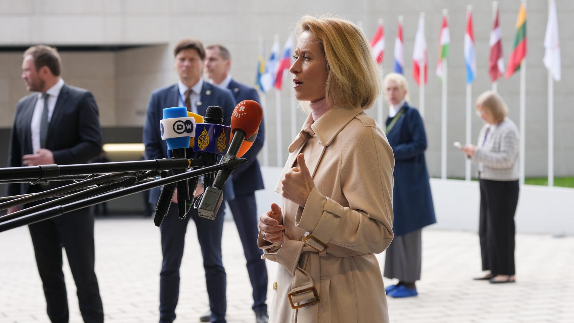 Luxemburg: Die Leiterin der Außenpolitik der Europäischen Union, Kaja Kallas, spricht in mehrere Mikrofone. Hinter ihr sind verschiedene europäische Flaggen.