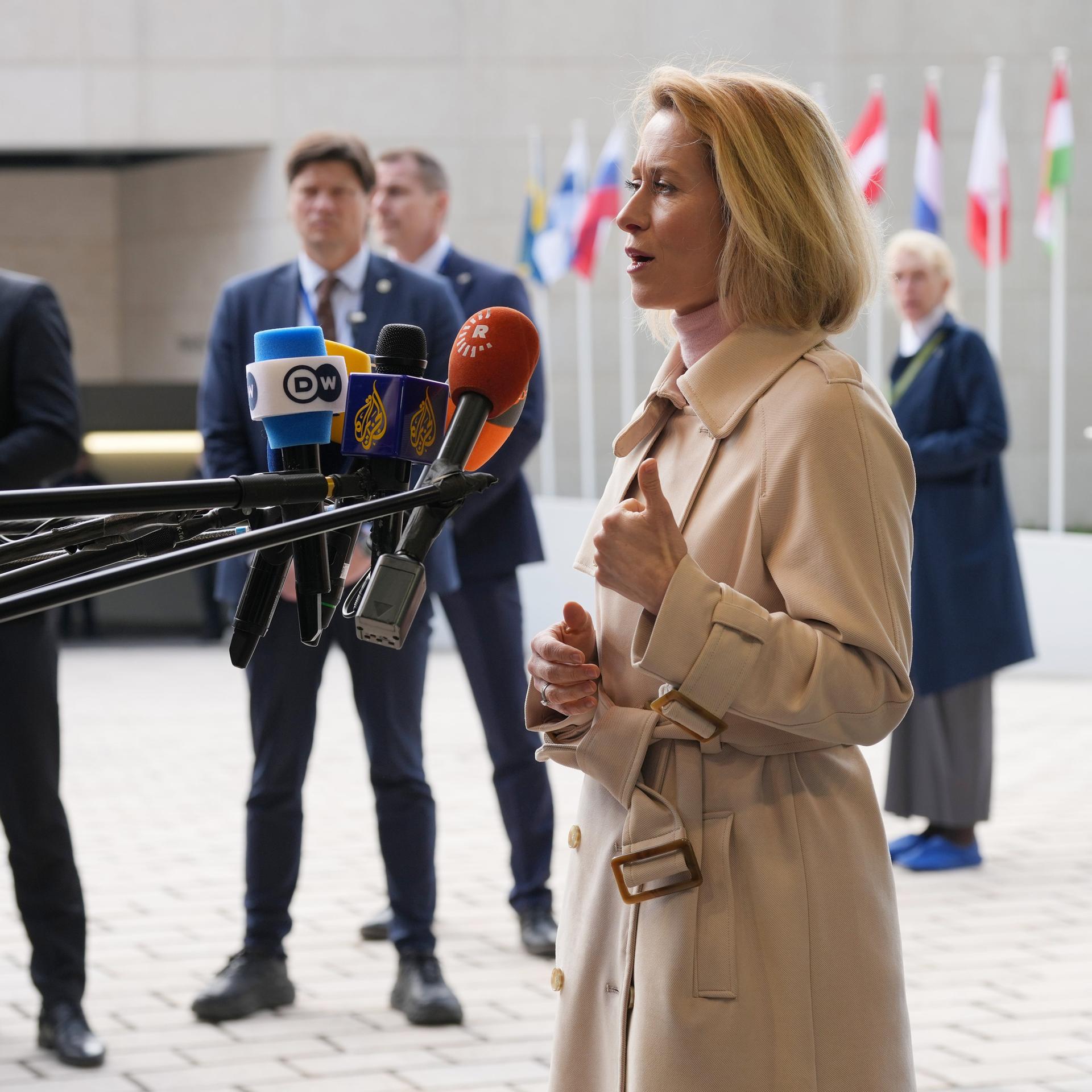Luxemburg: Die Leiterin der Außenpolitik der Europäischen Union, Kaja Kallas, spricht in mehrere Mikrofone. Hinter ihr sind verschiedene europäische Flaggen.