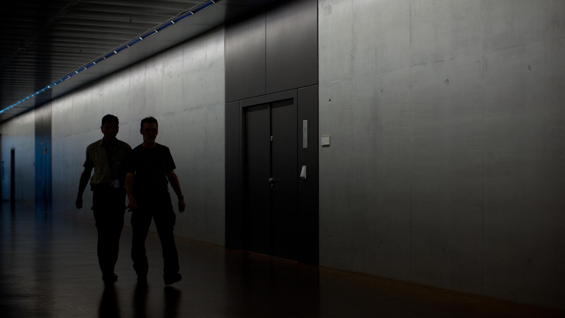 Zwei Männer gehen während einer Sondersitzung des Parlamentarischen Kontrollgremiums (PKGr) im Bundestag in Berlin am Sitzungssaal im Keller des Deutschen Bundestags vorbei.
