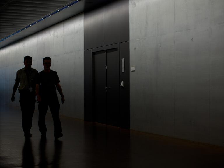 Zwei Männer gehen während einer Sondersitzung des Parlamentarischen Kontrollgremiums (PKGr) im Bundestag in Berlin am Sitzungssaal im Keller des Deutschen Bundestags vorbei.