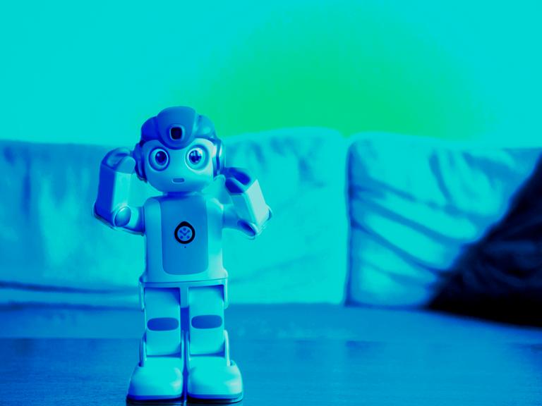 Robin - ein kleiner Roboter steht auf einem Tisch vor einem Sofa