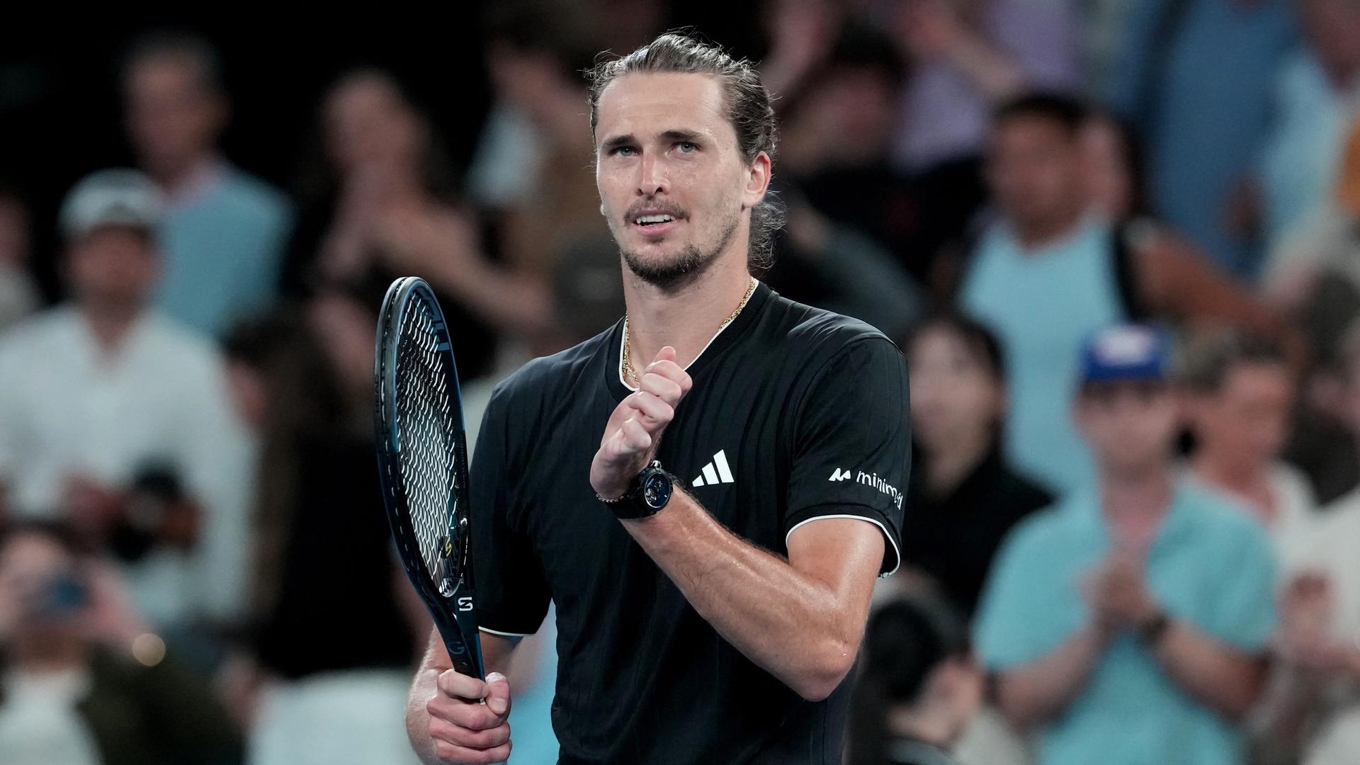 Der Tennisprofi Alexander Zverev klatscht mit dem Handballen auf seinen Tennisschläger.