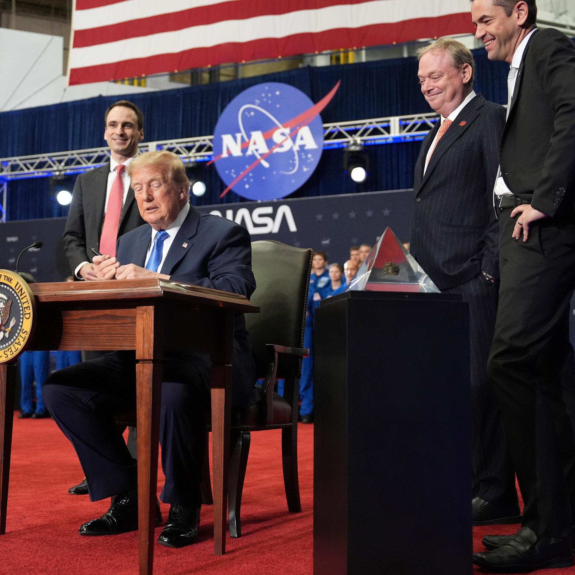 Donald Trump unterzeichnet ein Schriftstück. Darin wird die Gründung einer US Weltraum-Akademie angeordnet.