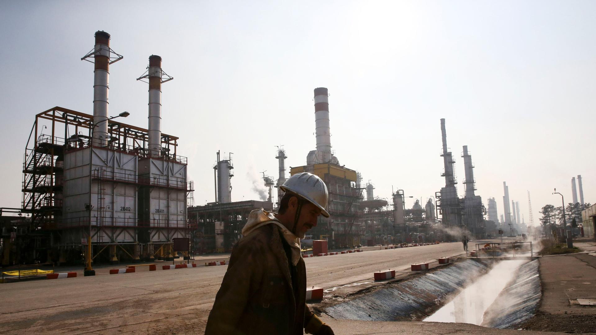 An Iranian oil worker makes his way through Tehran's oil refinery south of the capital Tehran, Iran, Monday, Dec. 22, 2014. (AP Photo/Vahid Salemi)