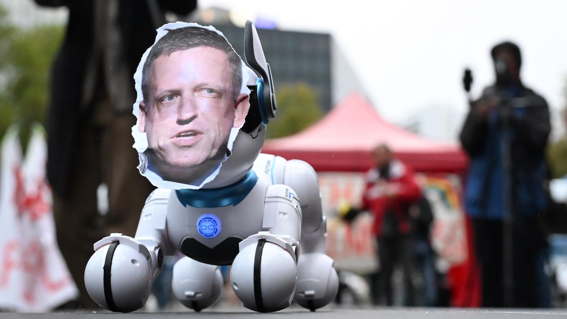 Das Foto Peter Thiels auf einem Roboterhund fotografiert während einer einer Kundgebung gegen die Verleihung des Axel Springer Awards an den Techn-Investor 