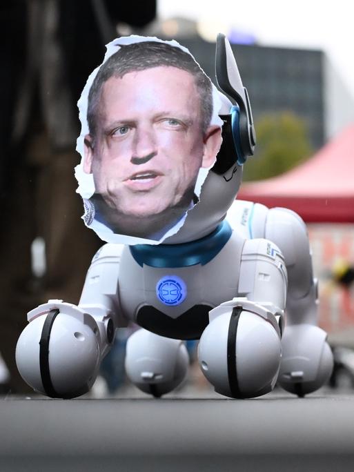 Das Foto Peter Thiels auf einem Roboterhund fotografiert während einer einer Kundgebung gegen die Verleihung des Axel Springer Awards an den Techn-Investor 