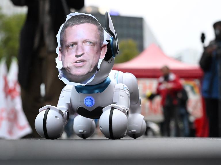 Das Foto Peter Thiels auf einem Roboterhund fotografiert während einer einer Kundgebung gegen die Verleihung des Axel Springer Awards an den Techn-Investor 