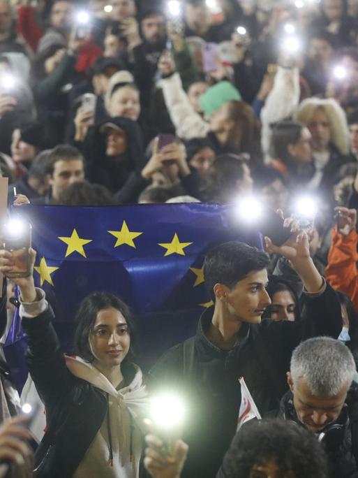 Menschen nehmen an einer Kundgebung der Opposition teil vor dem Parlamentsgebäude im Zentrum von Tbilisi.