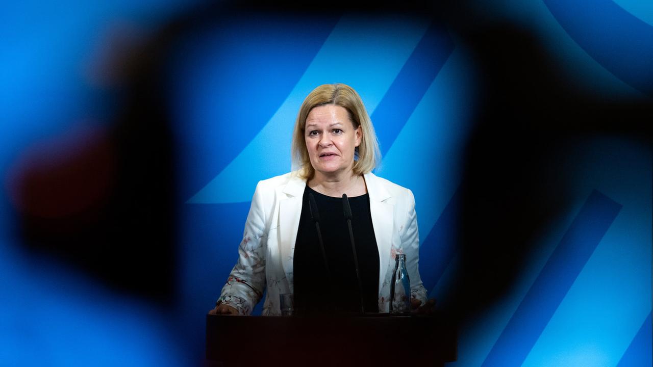 Nancy Faeser (SPD), Bundesministerin für Inneres und Heimat, vor blauen Hintergrund, steht an einem Rednerpult.