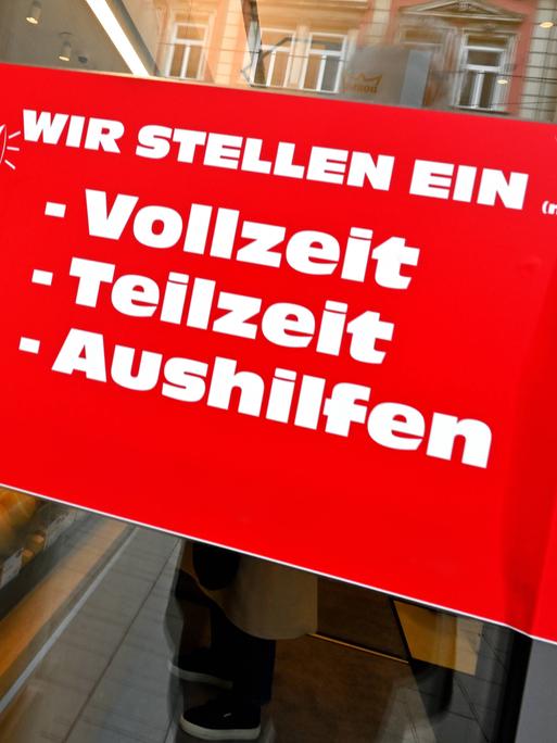 Auf einem roten Schild an der Glastür einer Bäckerei steht: "Wir stellen ein (m/w/d): Vollzeit, Teilzeit, Aushilfe" Auf einem roten Schild an der Glastür einer Bäckerei steht: "Wir stellen ein (m/w/d): Vollzeit, Teilzeit, Aushilfe"