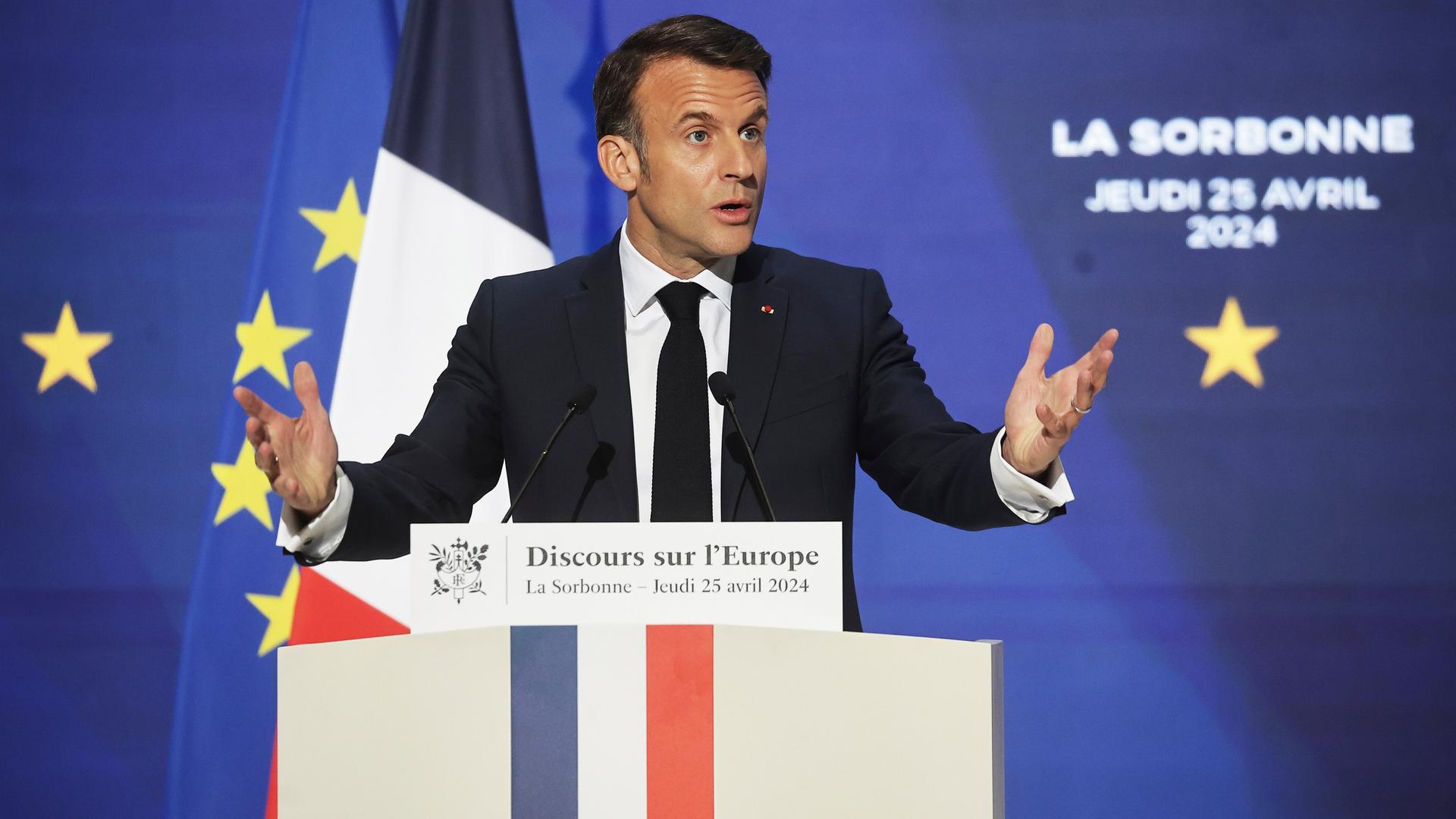 Paris: Der französische Präsident Emmanuel Macron hält eine Rede an einem Rednerpult vor einer französischen Flagge und der EU-Flagge.