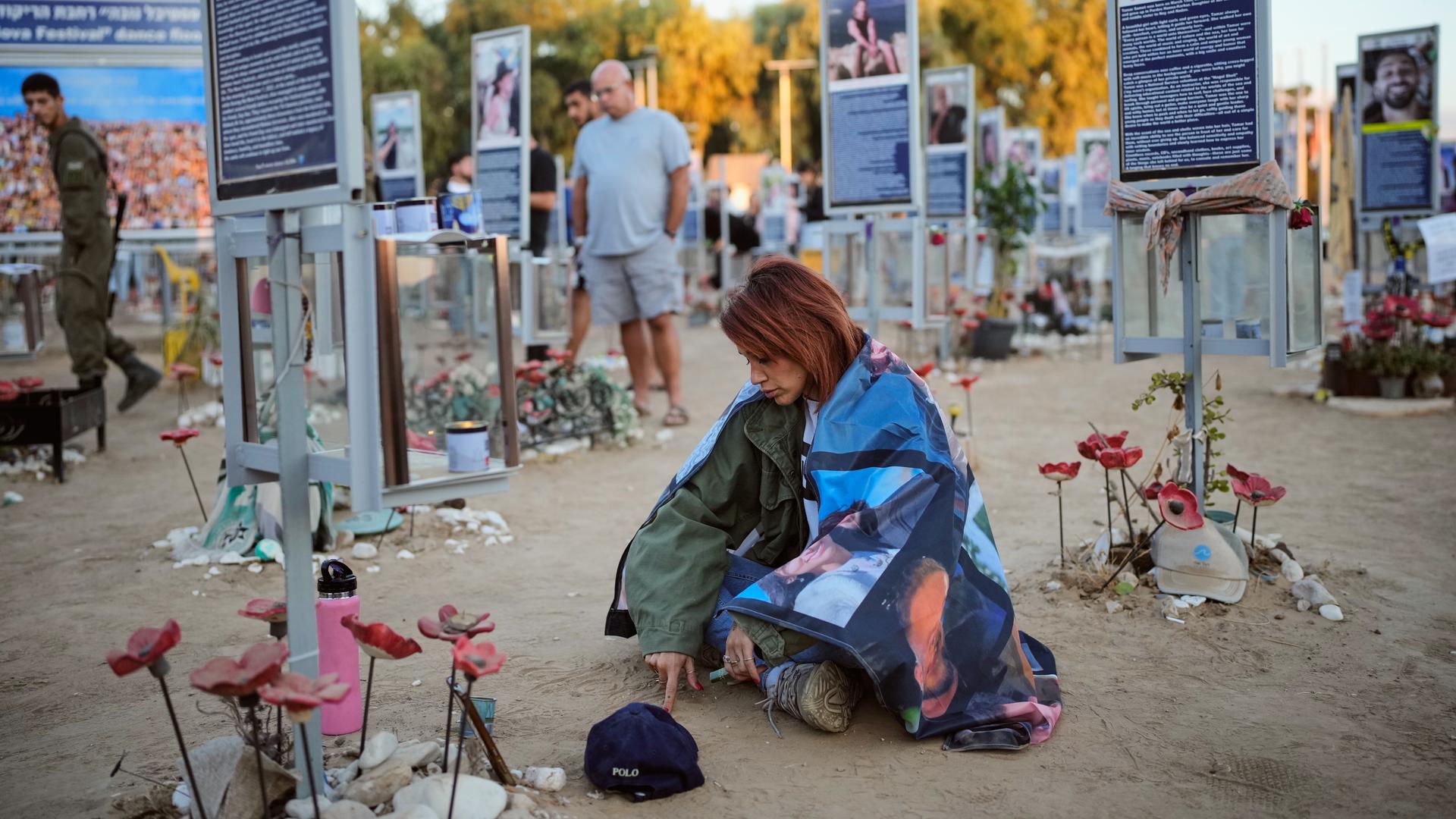 In Israel gedenken Menschen der Opfer des Hamas-Überfalls am 7. Oktober vor mehreren Tafeln, die Bilder der Ermordeten zeigen.