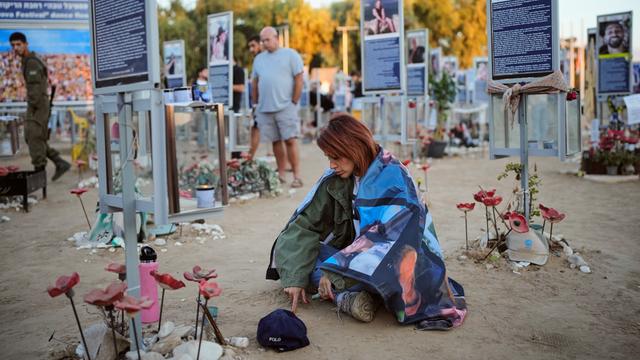 In Israel gedenken Menschen der Opfer des Hamas-Überfalls am 7. Oktober vor mehreren Tafeln, die Bilder der Ermordeten zeigen.