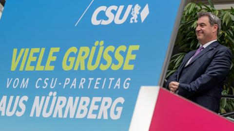 Markus Söder, Parteichef der CSU, fährt auf einer Rolltreppe zum CSU-Parteitag an einem Plakat vorbei