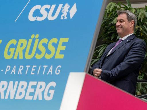 Markus Söder, Parteichef der CSU, fährt auf einer Rolltreppe zum CSU-Parteitag an einem Plakat vorbei