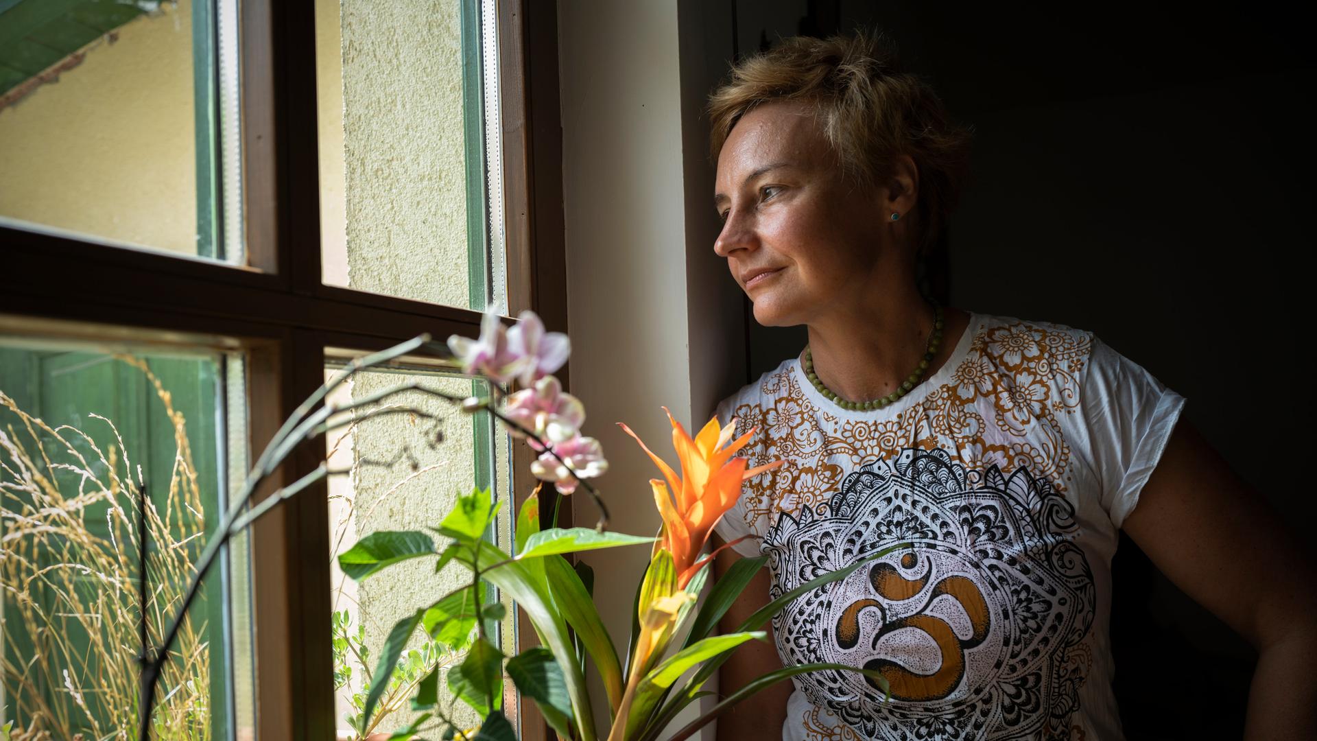 Die ungarische Schriftstellerin Noemi Kiss steht neben einem Fenster mit Pflanzen auf der Fensterbank 