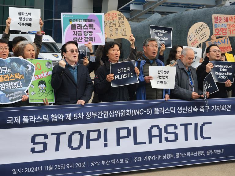 Umweltaktivistien stehen mit einem großen "Stopp-Plastik"-Transparent vor dem Tagungsort des UNO-Plastikabkommens im südkoreanischen Busan.South Korea, Monday, Nov. 25, 2024. (Cha Keun-ho/Yonhap via AP)