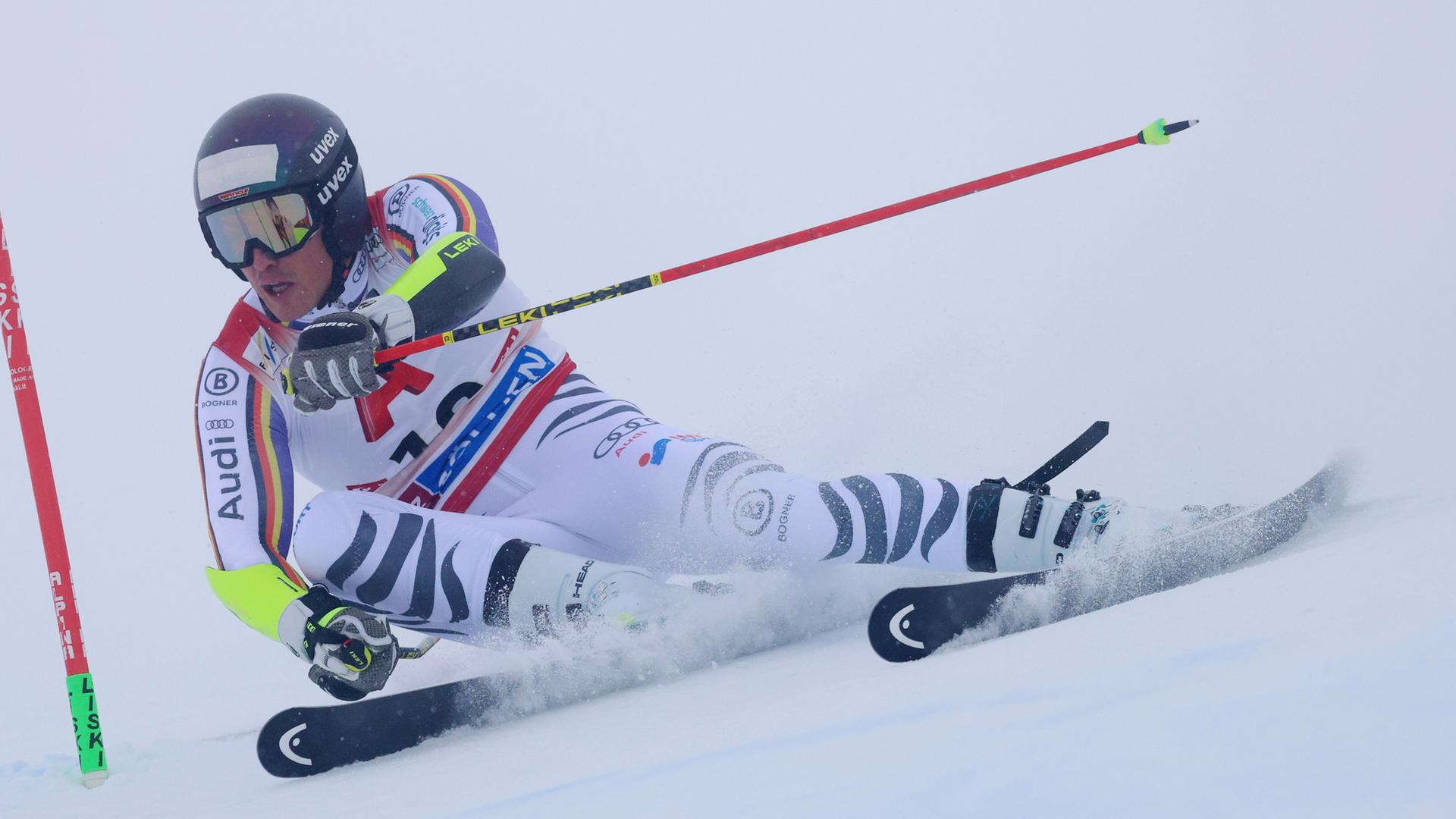 Anton Grammel legt sich in die Kurve. Er trägt einen weißen Ski-Anzug und einen schwarzen Helm. Anton Grammel legt sich in die Kurve. Er trägt einen weißen Ski-Anzug und einen schwarzen Helm.
