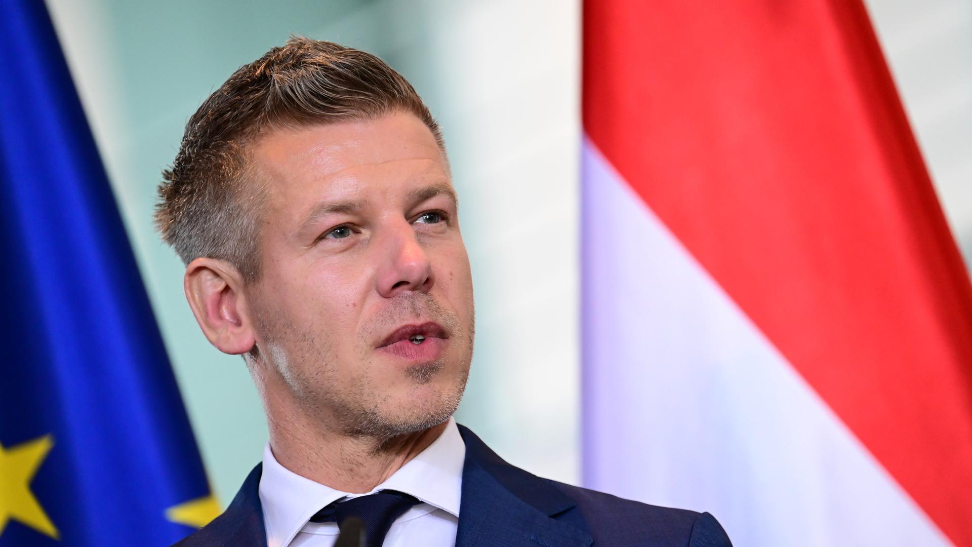 Peter Magyar, Ungarns Ministerpräsident, steht vor der ungarischen und der EU-Flagge. 