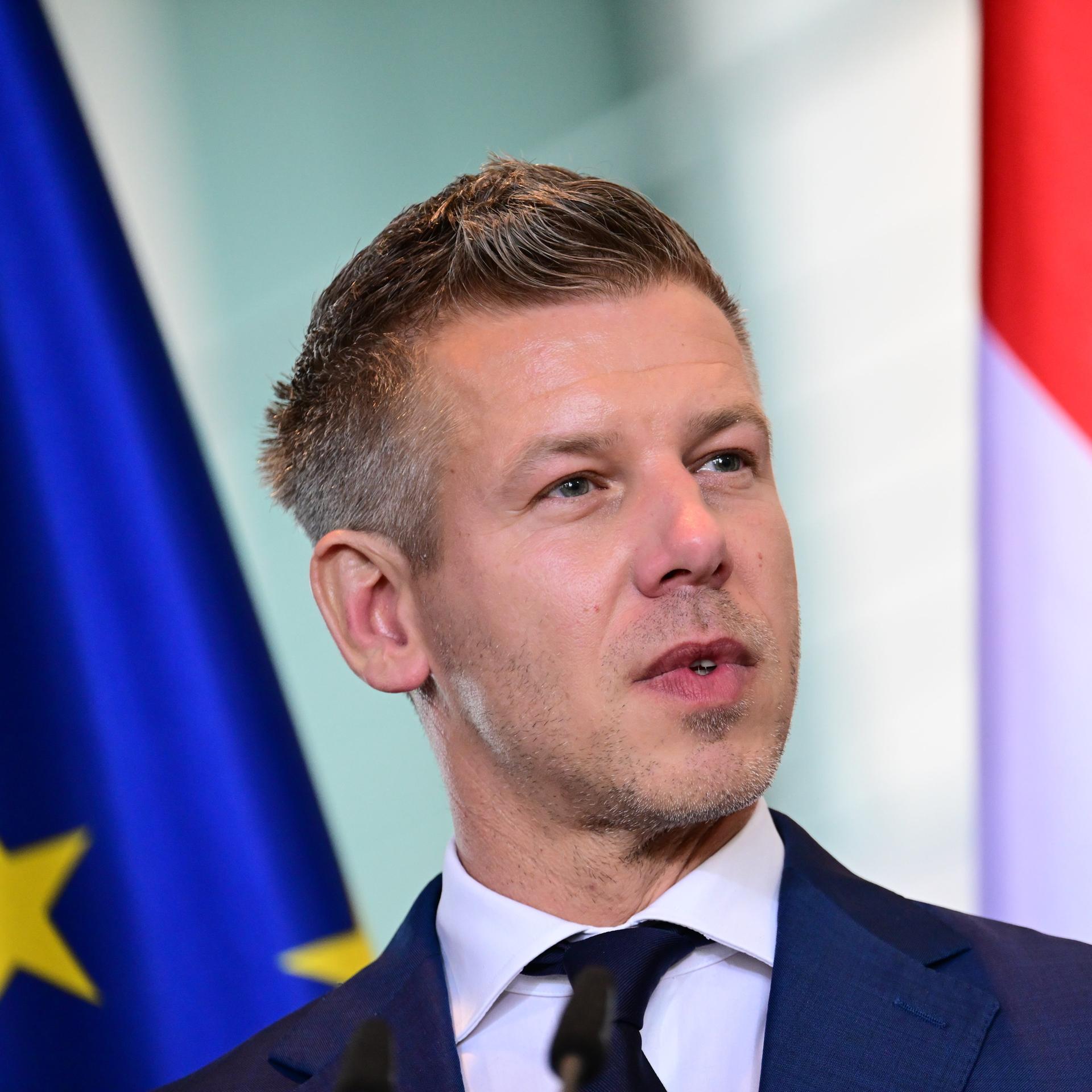 Peter Magyar, Ungarns Ministerpräsident, steht vor der ungarischen und der EU-Flagge. 