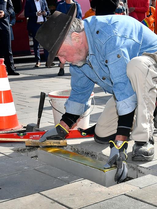 Der Künstler und Stolperstein-Erfinder Gunter Demnig verlegt eine Stolperschwelle zum Gedenken an verfolgte Homosexuelle in Bochum.