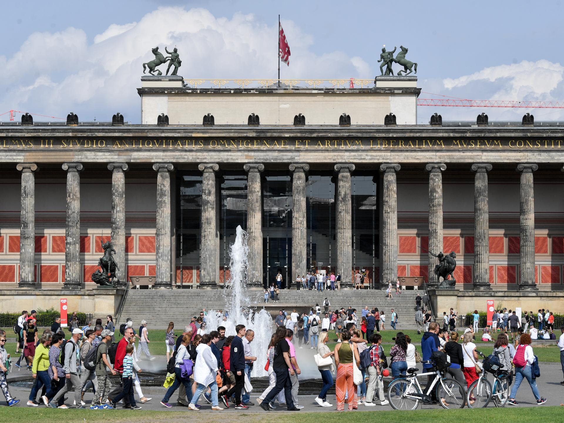 Zahlreiche Menschen spazieren bei sonnigen Wetter durch den Lustgarten in Berlin Mitte