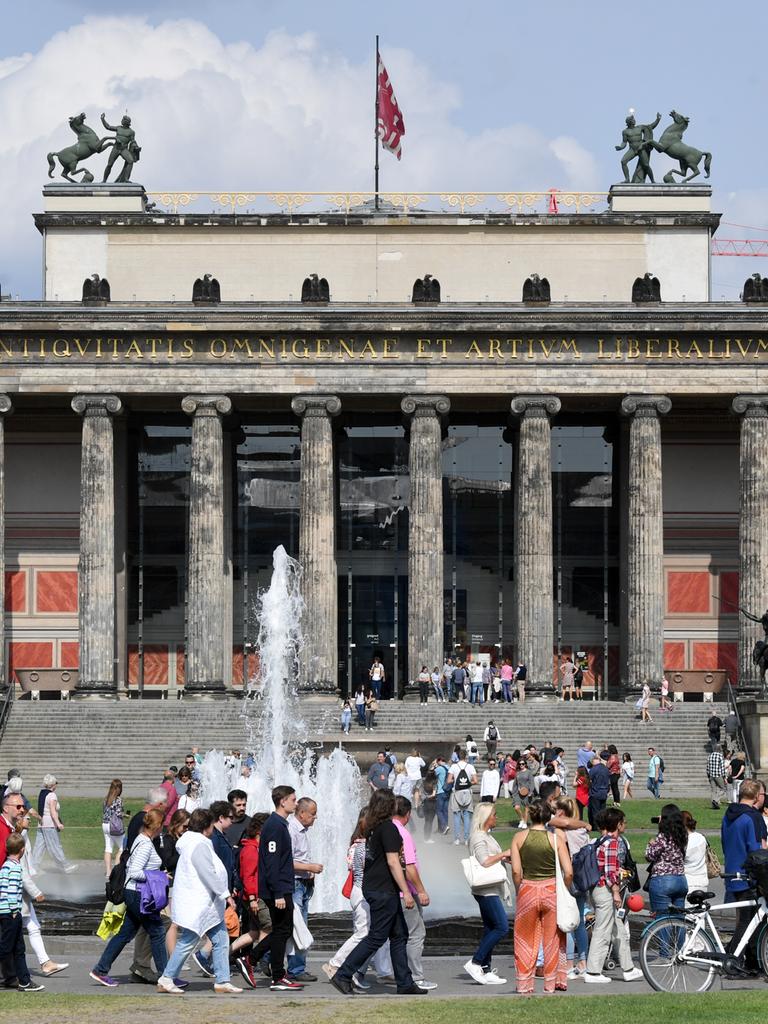Zahlreiche Menschen spazieren bei sonnigen Wetter durch den Lustgarten in Berlin Mitte