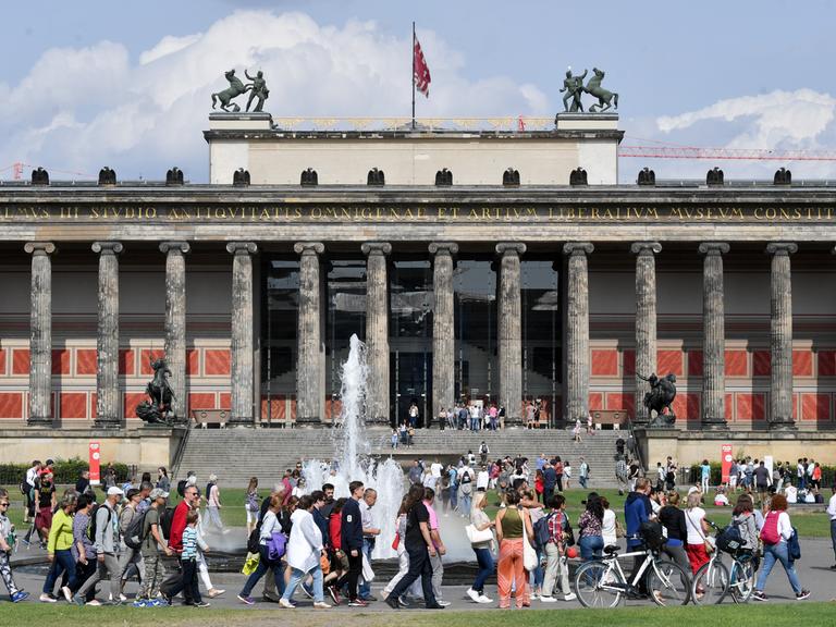 Zahlreiche Menschen spazieren bei sonnigen Wetter durch den Lustgarten in Berlin Mitte
