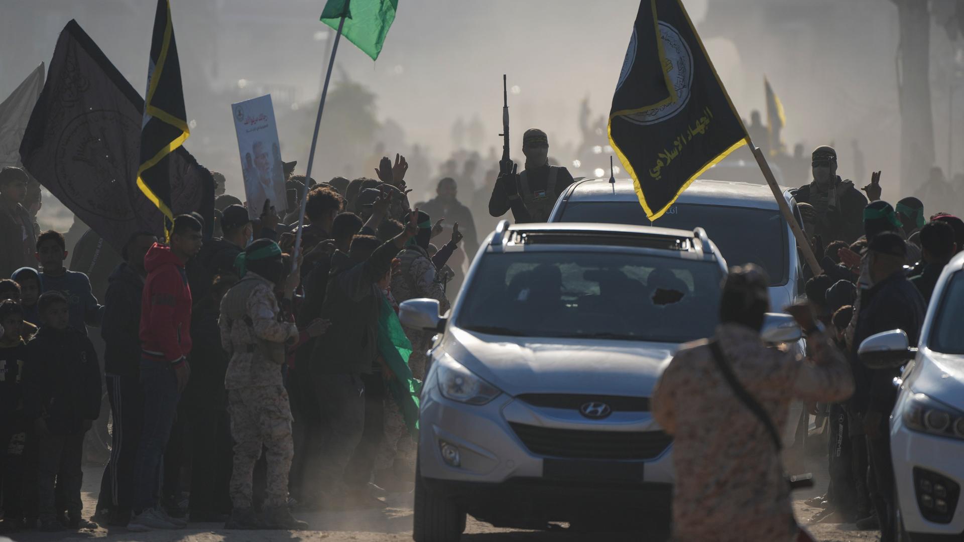 Eine Menschenmenge begrüßt Kämpfer des Islamischen Dschihad und der Hamas bei ihrer Ankunft zur Übergabe von israelischen und thailändischen Geiseln an das Rote Kreuz im südlichen Gazastreifen. Eine Menschenmenge begrüßt Kämpfer des Islamischen Dschihad und der Hamas bei ihrer Ankunft zur Übergabe von israelischen und thailändischen Geiseln an das Rote Kreuz im südlichen Gazastreifen.